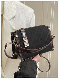 Detailed view of the quilted texture and golden twist-lock on this vintage handbag
