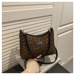 Close-up of leopard print shoulder bag with black leather strap and silver metal buckle