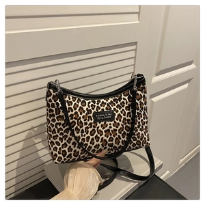 Close-up of leopard print shoulder bag with black leather label and metallic zipper detail