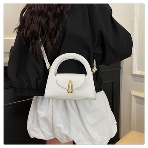 Detail of white leather handbag with elegant gold metal buckle and sleek crossbody strap