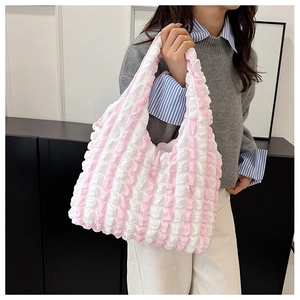 Detail of pink striped tote bag with pleated seersucker texture on shoulder strap