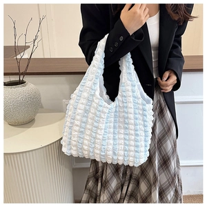 Close-up of blue and white striped popcorn fabric texture on a soft tote bag