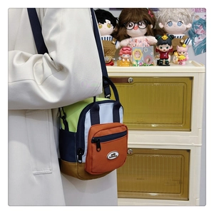 Detail of multi-color patchwork crossbody bag with nylon texture and front zipper pocket