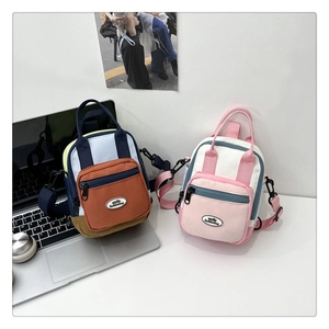 Detail view of two mini nylon multi-way backpacks with color-block design and adjustable straps