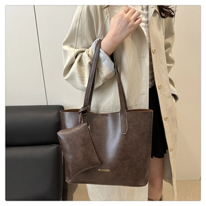 Close-up of vintage brown leather tote bag with matching mini pouch and gold logo detail