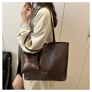 Detail of vintage dark brown tote bag with matching pouch and gold MS.HUIXIBAG logo