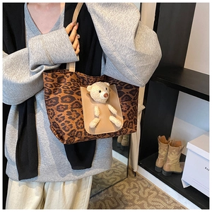 Detailed view of leopard canvas tote featuring a 3D plush bear pocket and side profile