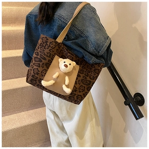 Close-up of leopard print tote bag featuring a cute 3D plush bear detail and wide handles