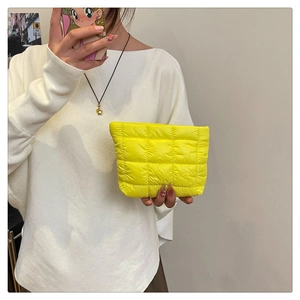 Close-up of bright yellow quilted nylon pouch with square lattice embroidery texture