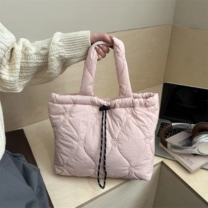 Sac fourre-tout matelassé rose à motifs de cœurs avec cordons dans un décor décontracté