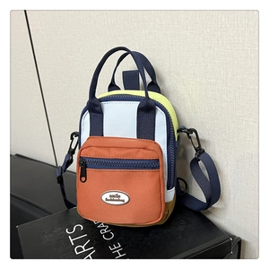 Detailed view of mini color-block crossbody bag featuring orange, blue and green canvas