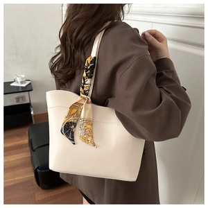 Detail of off-white tote bag with decorative printed scarf on the handle and stitching