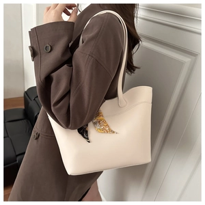 Close-up of cream white PU leather tote bag with geometric silk scarf decoration