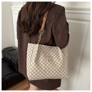 Détail du cabas monogramme beige avec logo M doré et bandoulière en cuir et chaîne