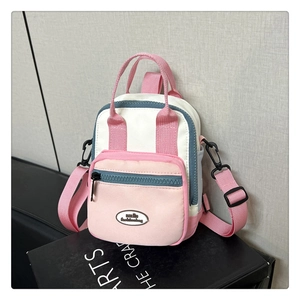 Detailed macro view of the tri-color mini backpack with premium zipper and logo plaque