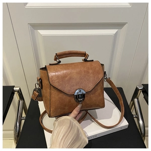 Detailansicht der braunen Vintage-Handtasche mit silbernem Drehverschluss und Griff