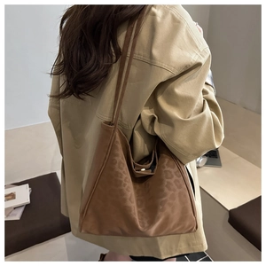 Model wearing a large brown tote bag with animal print texture for autumn commuting