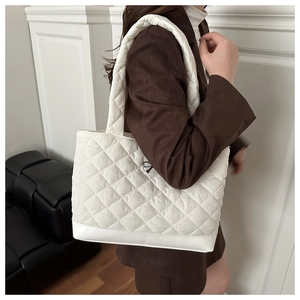 Detail of white quilted tote bag texture showing elegant diamond stitching on fabric