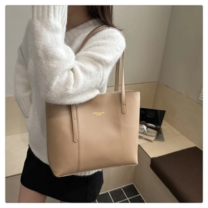 Detail of minimalist beige leather tote bag with elegant Fashion & Bags embossed text