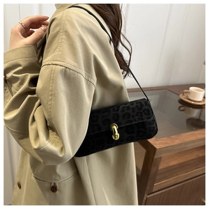 Gros plan du sac sous le bras à motif léopard noir avec fermoir cylindrique doré