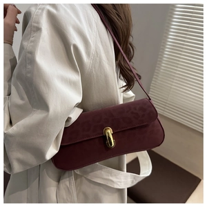 Detail der burgunderroten Schultertasche mit Leopardenmuster und goldenem Verschluss