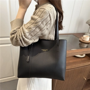 Classic black leather tote bag for women featuring long shoulder straps and gold lettering