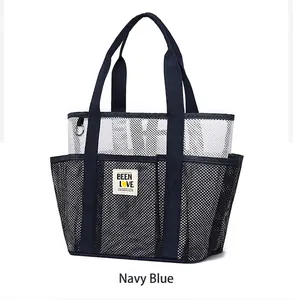 Navy blue and white mesh beach bag detail with branded logo patch and multi-pocket design