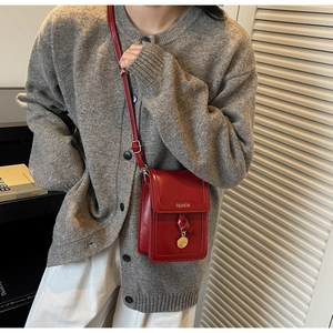 Gros plan sur un mini sac bandoulière rouge vif avec lettrage FASHION jaune et détails