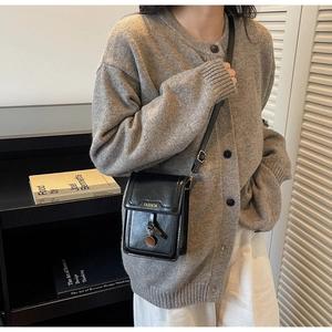 Détail du mini sac bandoulière en cuir PU noir brillant avec lettrage FASHION et breloque