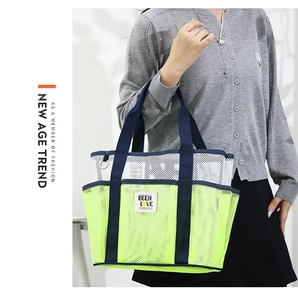 Detail of neon green mesh beach bag with sturdy navy blue woven straps and branding tag