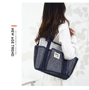 Deep blue and white mesh beach bag detail showing multiple functional side pockets and mesh
