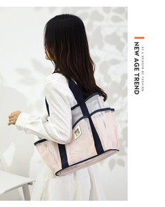 Pink mesh beach tote detail with navy blue handles and Been Love logo on white wall