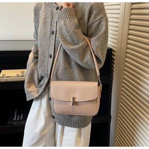 Detailed view of the minimalist beige leather crossbody bag featuring a sleek metal buckle