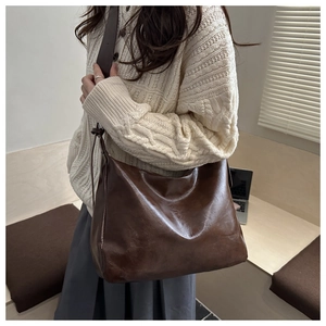 Vue détaillée d'un grand sac cabas marron en cuir ciré porté à l'épaule dans un style décontracté
