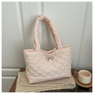 Detail of pink quilted tote bag featuring a silver bow and elegant diamond stitching