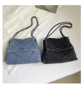 Detail of denim shoulder bags with metal chain straps in blue and vintage grey tones