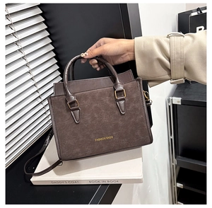 Gros plan détaillé d'un sac cabas vintage marron foncé avec cuir synthétique texturé et doré