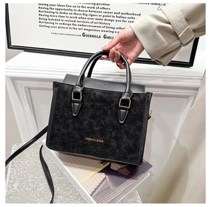 Détail d'un sac à main noir vintage en cuir texturé avec inscription Fashion Bags