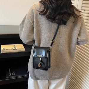 Sacoche noire chic pour téléphone avec pendentif doré et bandoulière réglable