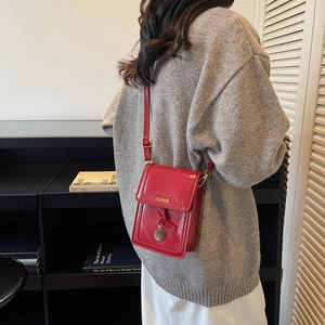 Petit sac bandoulière rouge brillant pour femme avec pendentif doré et logo tendance