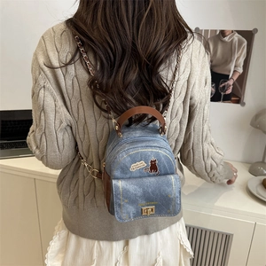 Mini sac à dos en jean avec imprimé chat et lanières en cuir porté par un mannequin
