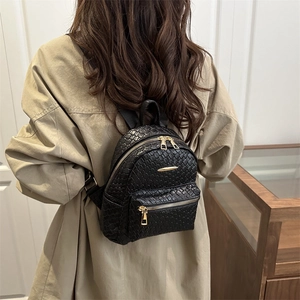 Chic black mini leather backpack with woven texture and gold zippers for women's casual travel