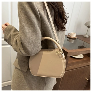 Beige faux leather handbag styled with a brown blazer in a cozy living room scene