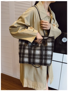 Detail of classic black and white plaid tote bag with plush wool texture and leather strap