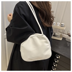 Close-up of white leather handbag with sleek texture and elegant thin dual straps