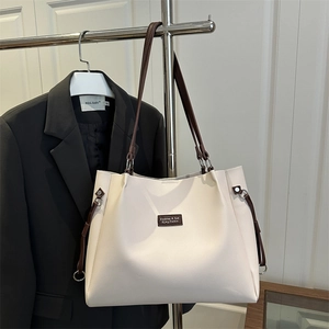 Minimalist off-white leather tote bag with brown straps for commuting and office use