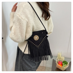 Detail of black suede crossbody bag with gold studs and cascading fringe tassels
