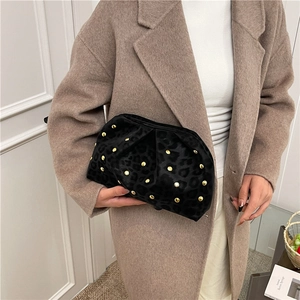 Leopard print pleated clutch with gold rivets shown in a stylish hand-held pose