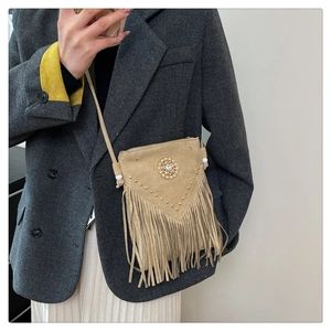 Close-up of khaki suede handbag with rhinestone, rivets, and stylish fringe details