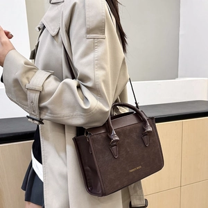Sac à main vintage marron foncé avec bandoulière et logo doré pour look de bureau